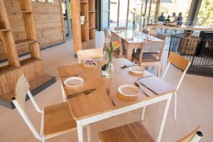 Table for four set beside timber shelving in the Barn restaurant, Old Mac Daddy, Elgin Valley