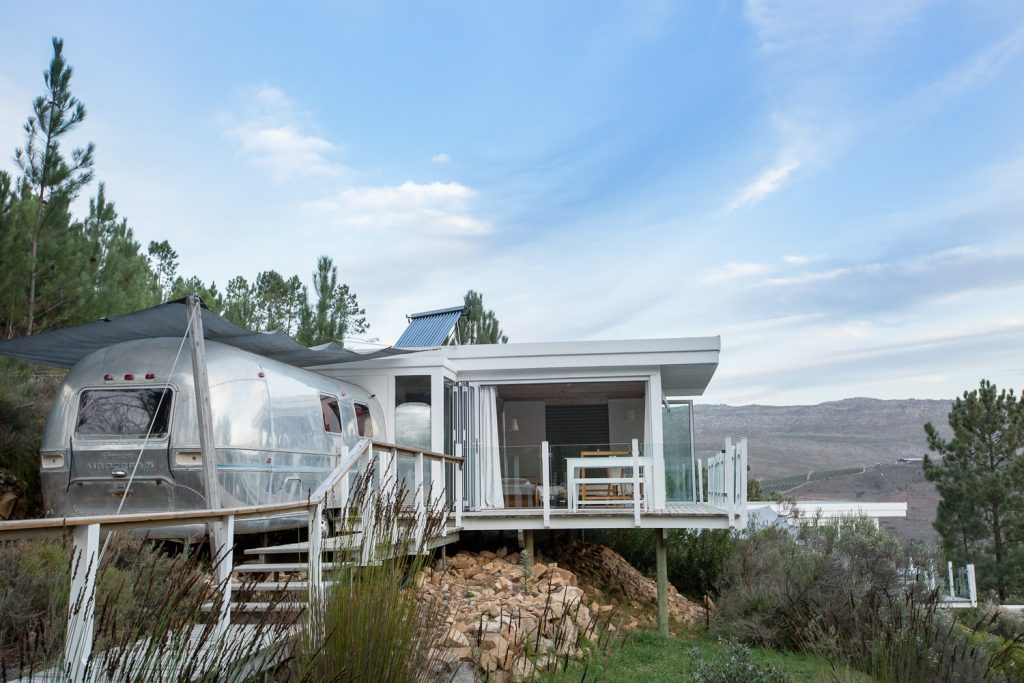 An Airstream joined to a white glass-fronted deck on the hillside, Old Mac Daddy, Elgin Valley