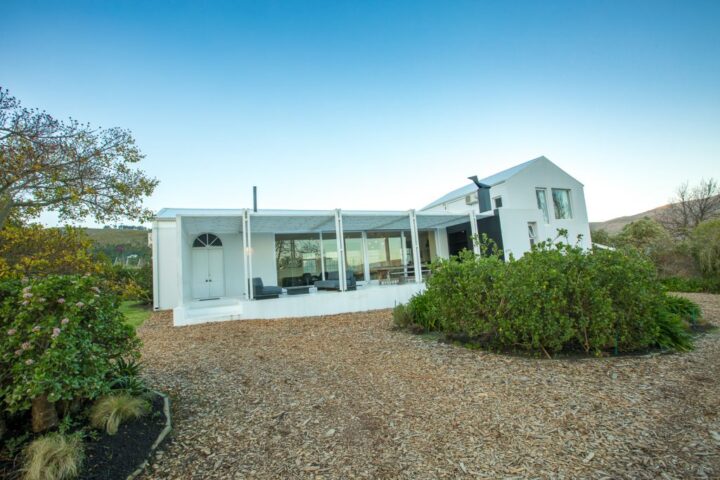 White villa with a slatted pergola, set in a gravel garden, Old Mac Daddy, Elgin Valley