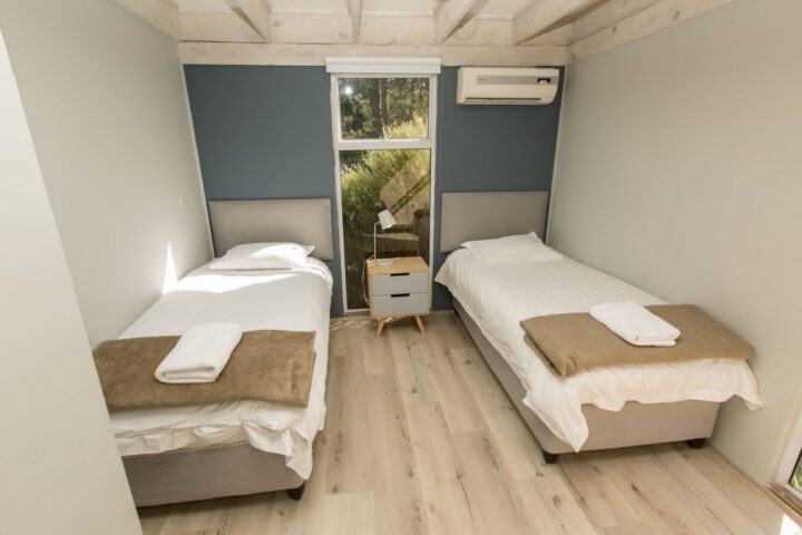 Villa bedroom with two single beds and a tall window, Old Mac Daddy, Elgin Valley