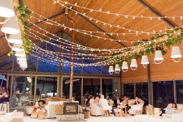 The Barn at night lit by strings of festoon lights, with guests in the lounge, Old Mac Daddy, Elgin Valley