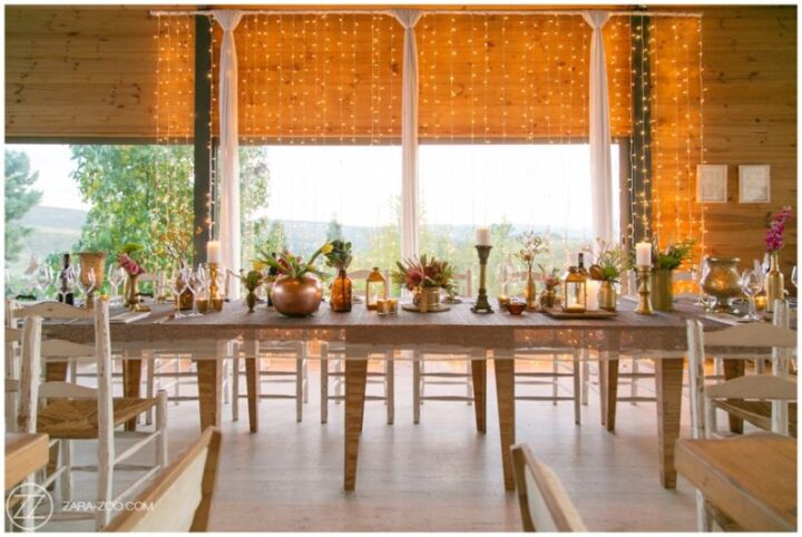 Wedding table dressed with candles and flowers in front of a curtain of fairy lights, Old Mac Daddy, Elgin Valley