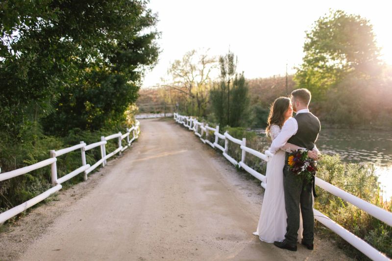 Bride and groom on a fenced dirt road beside the lake, Old Mac Daddy, Elgin Valley